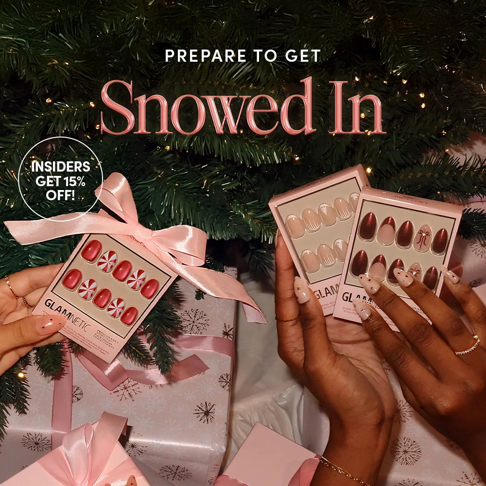 Two hands hold boxes of press-on nails in festive designs under a decorated Christmas tree, surrounded by pink-wrapped gifts. Text reads: Prepare to Get Snowed In. Insiders Get 15% Off!.