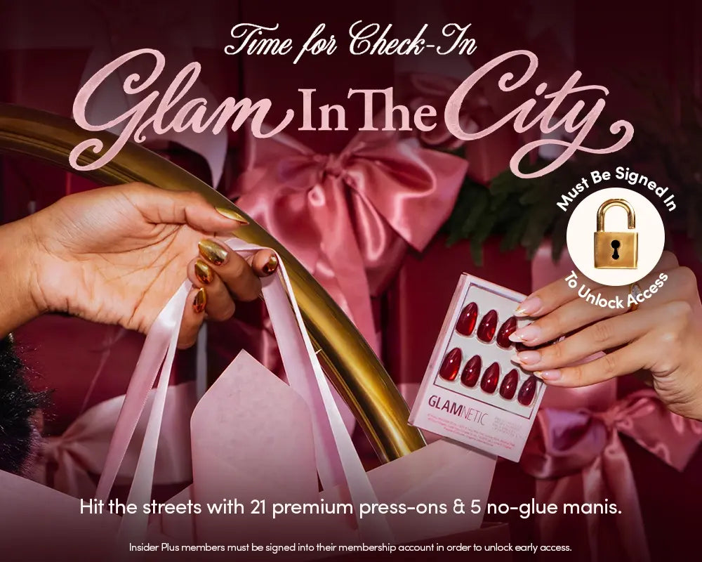 Two hands hold pink shopping bags and red press-on nails, with a pink satin background and glam decor. Text promotes Glam In The City press-ons, requiring sign-in for early access.