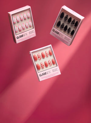 Three boxes of Glametric press on nails on a pink background