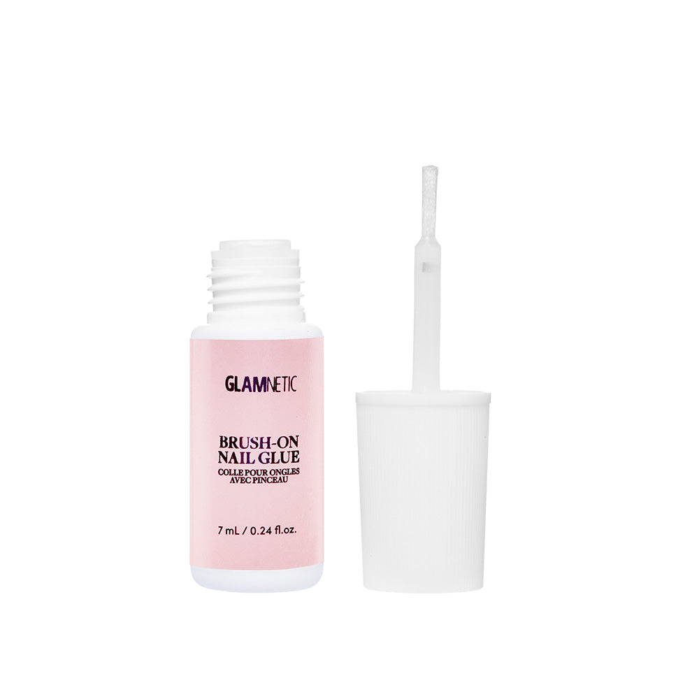 A bottle of glamnetic Brush-On Nail Glue with a pink label, displayed upright with the cap and brush applicator removed—ideal for achieving salon-style nails at home or applying your favorite press-on nails.