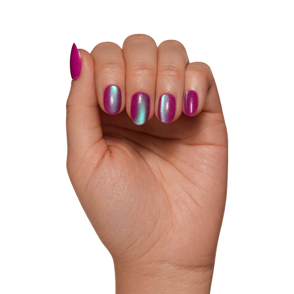 A hand with nails painted in glamnetics Berry Fizz Nail Set features a metallic pink and blue ombre polish with a velvet finish, highlighted against a white background to show its iridescent magenta hue. - Product image