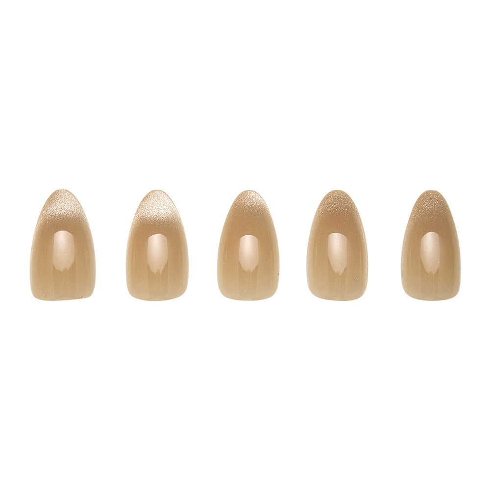 Five short almond-shaped artificial nails from the glamnetic Honey Bun set, featuring a smooth, glossy beige velvet finish, are arranged in a row on a white background. - Product image