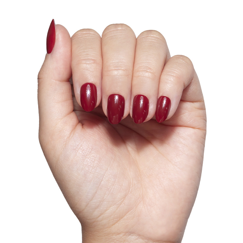 A hand with neatly manicured nails painted a glossy dark red Marauders Map™ shade by glamnetic is shown against a white background. This vegan, cruelty-free polish offers a guilt-free, glamorous look. - Product image