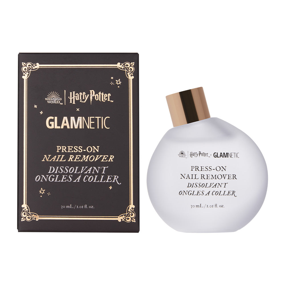 A 30ml bottle of glamnetic Harry Potter™ Press-On Nail Remover, an acetone-free formula, is displayed beside its decorative black and gold box. The white bottle has a gold cap and black front text. - Product image