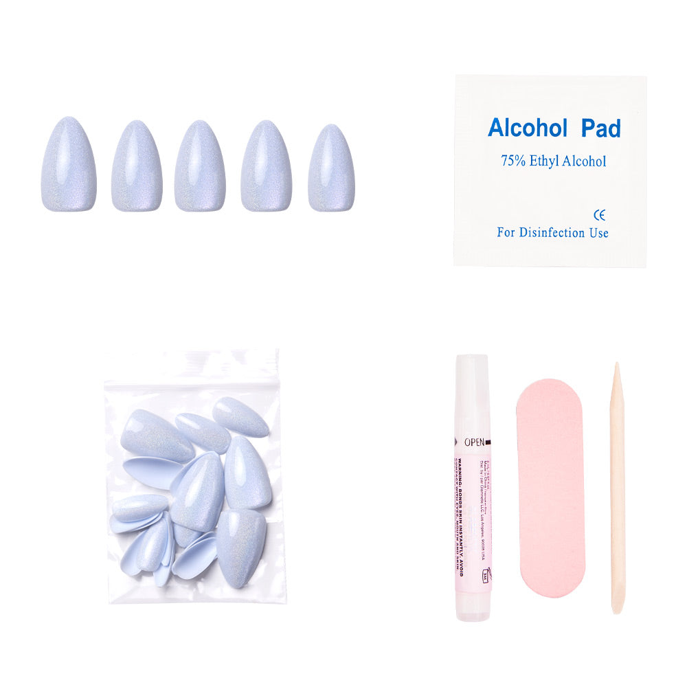 The Frozen nail set by glamnetic features light blue, short almond press-on nails. It includes an alcohol pad, extra nails, glue, a pink file, and a cuticle stick—all displayed on a white background. - Product image