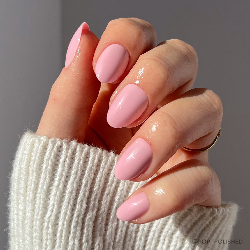 Show off your glamnetic Think Pink nails—neatly manicured, almond-shaped baby pink tips paired with a white knit sweater and a gold ring—for a flawless, stylish look. - Product image