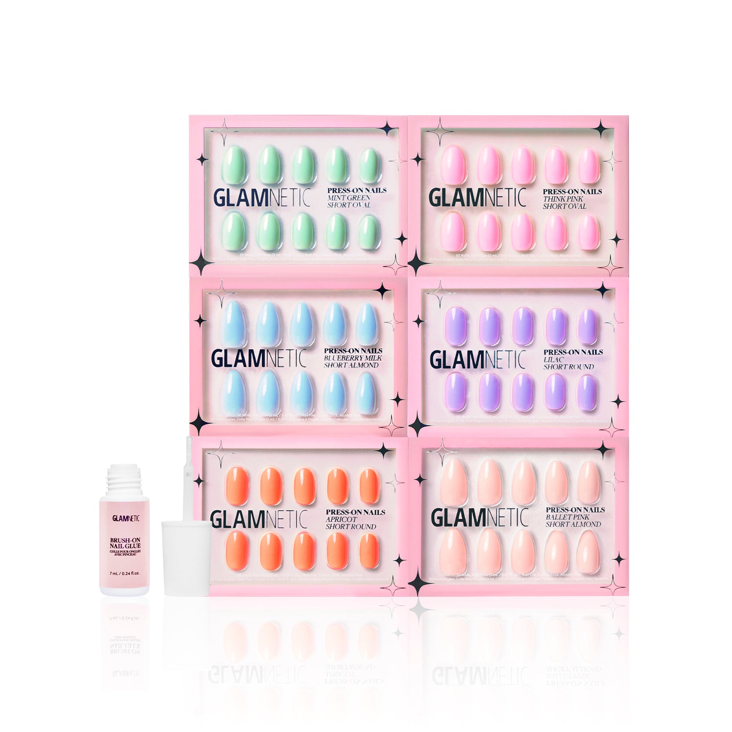 Six boxes of glamnetics The Solids: Spring Bloom Collection Press-On Nails in pastel shades are stacked in two rows, each showing ten nails. A glamnetic nail glue bottle with the lid off sits on the left. - Product image