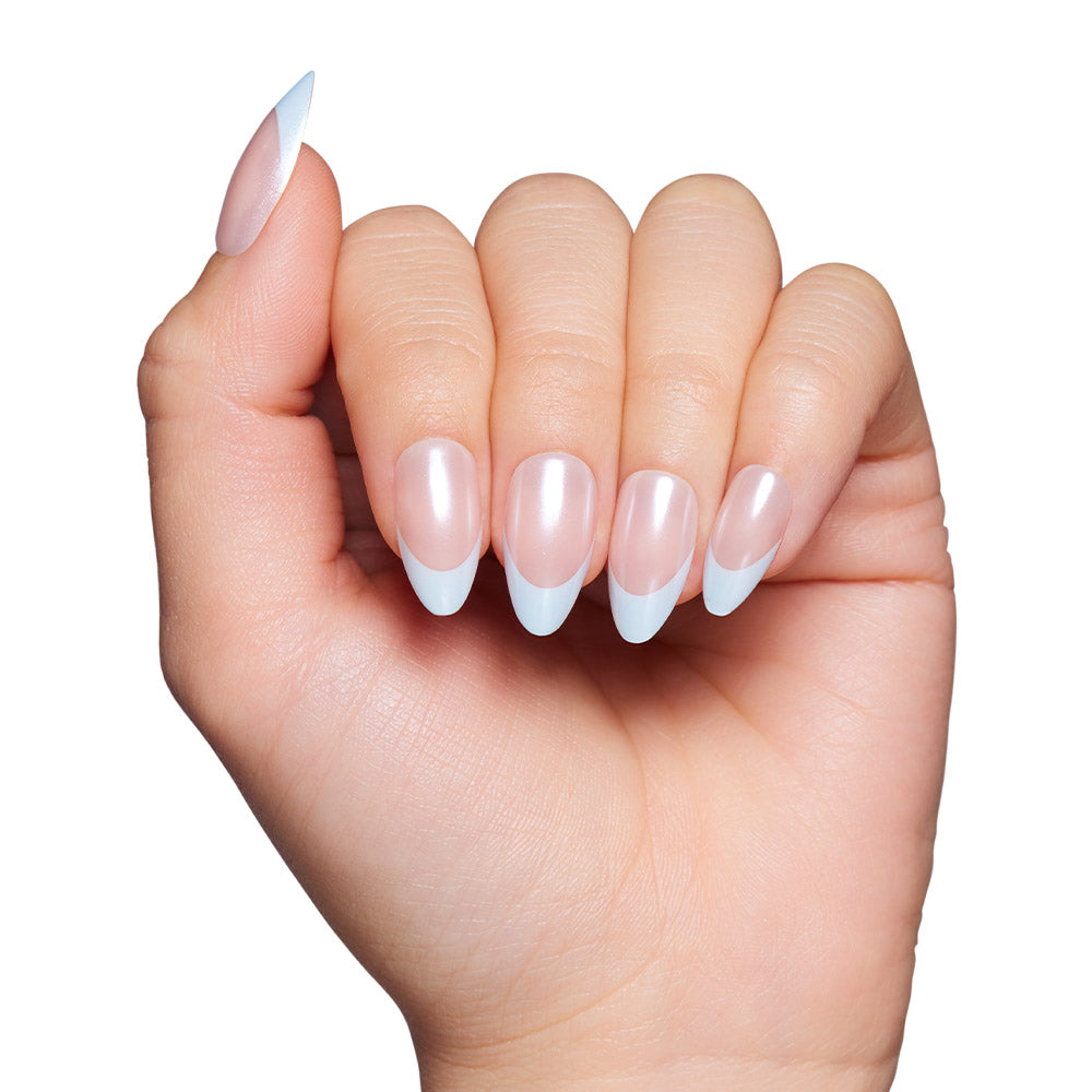 A hand with light skin tone displays manicured, almond-shaped nails in glamnetics Blueberry Icing: a pale pink base with a glazed finish and baby blue French tips. The background is white. - Product image