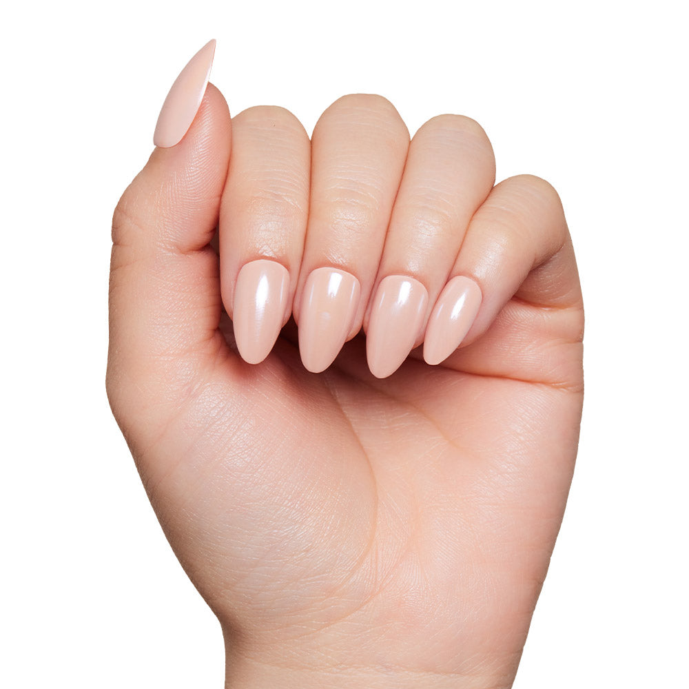 A hand with short almond-shaped glamnetic Los Angeles nails in a glossy nude-blush shade, shown against a white background. - Product image