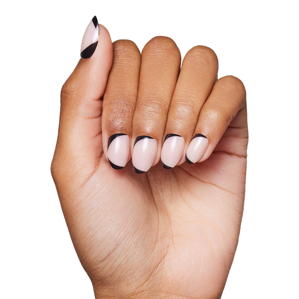 A hand with light pink glamnetic NYC Press-On Nails featuring a black abstract tip design, shown against a white background. The neat, modern manicure offers a chic, minimalist look—perfect for stylish press-on nail lovers. - Product image