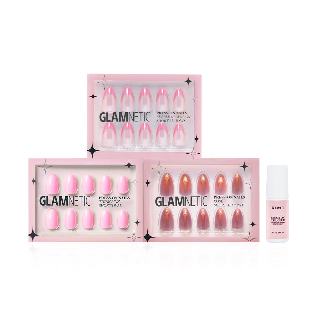 Three pink and nude-toned glamnetic press-on nail sets, including Blush Crush, arranged in staggered rectangular boxes alongside a small white bottle of glamnetic nail glue. - Product image