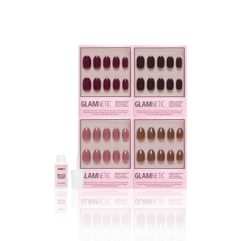 Four boxes of glamnetic Fauna & Flora vegan & cruelty-free press-on nails in pink, brown, and mauve are displayed upright with nail glue in front, all set against a white background. - Product image