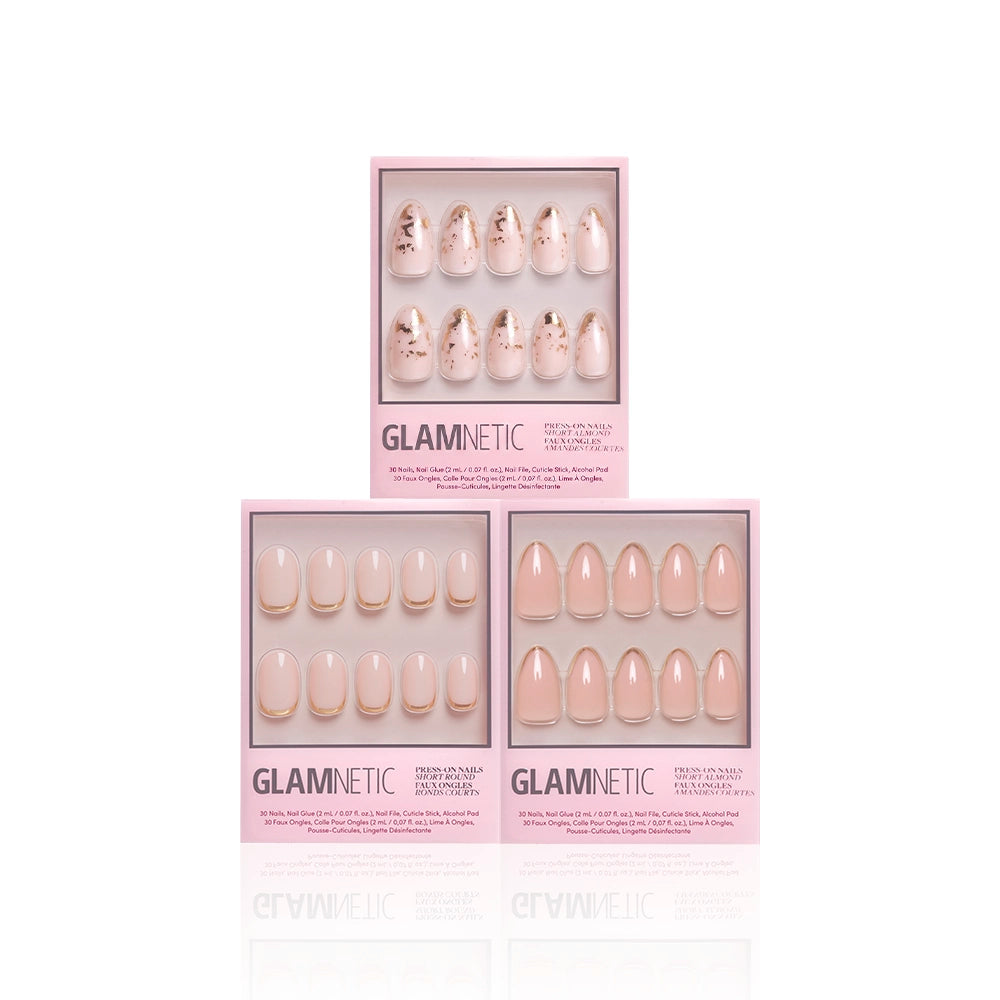 Three boxes of glamnetics Golden Goddess press-on nails are shown. The top has floral and gold foil accents, while the two below display simple nude styles—one with white tips, one with gold tips—all set against a pink background. - Product image