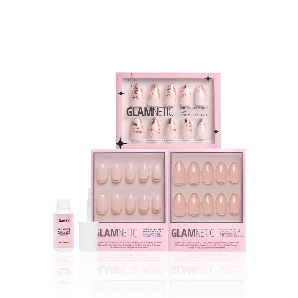 Three pink boxes of glamnetic Golden Goddess press-on nails with elegant nude and blush designs and gold foil accents, plus a small nail glue bottle and white applicator, are displayed on a white background. - Product image