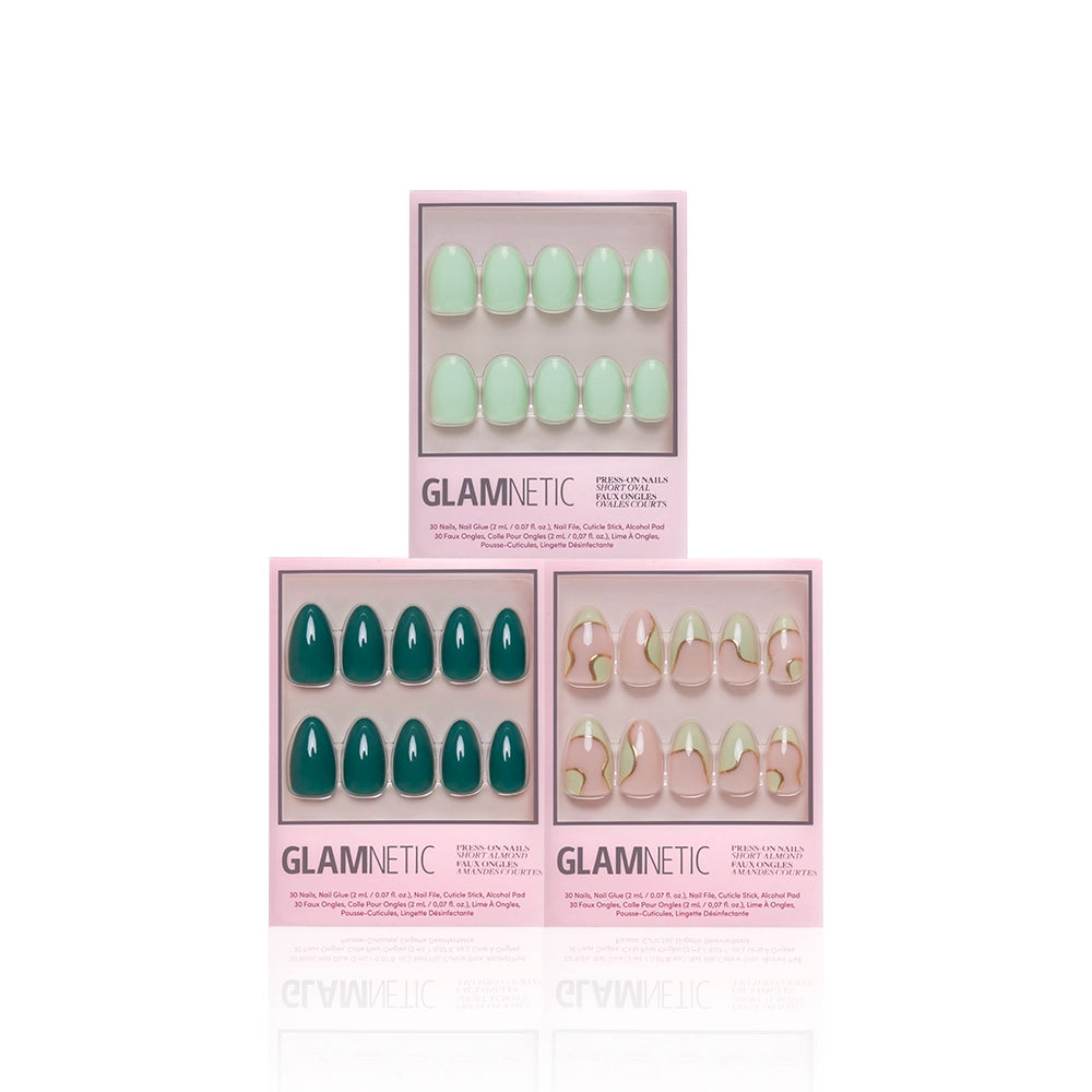 Three boxes of glamnetic Green Enchantment press-on nails are shown: the top features light green nails, while the bottom two display emerald green and nude nails with green and gold abstract designs—all with salon-quality durability. - Product image