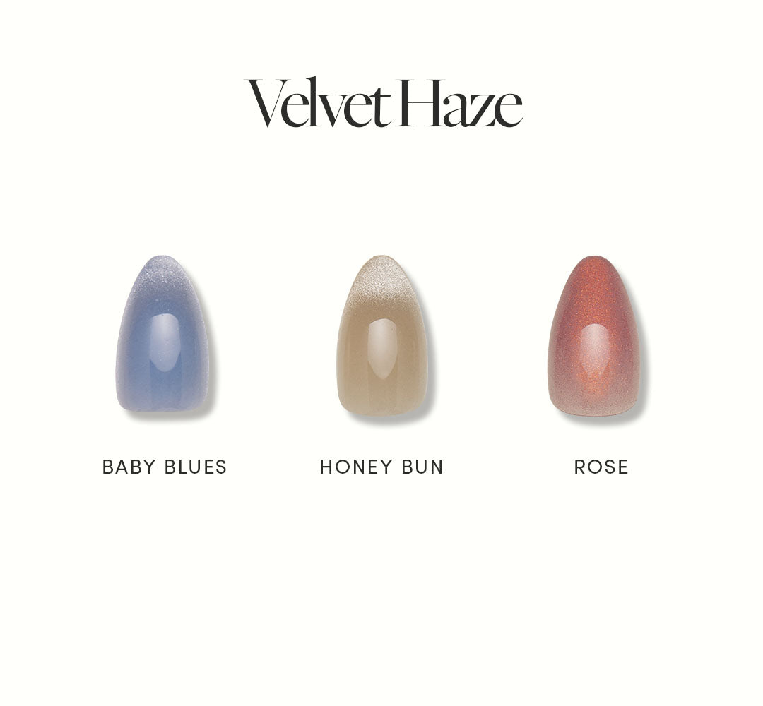 Three short almond nails by glamnetic are shown side by side for Velvet Haze, featuring a velvet finish in Baby Blues, Honey Bun, and shimmery Rose—each vegan and cruelty free. - Product image
