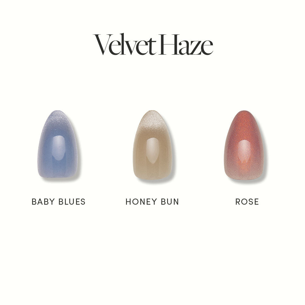 Three short almond nails by glamnetic are shown side by side for Velvet Haze, featuring a velvet finish in Baby Blues, Honey Bun, and shimmery Rose—each vegan and cruelty free. - Product image