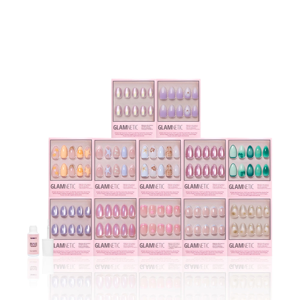 Ten boxes of glamnetic’s Sirens Cove Collection press-on nails, showcasing pastel hues and 3D art, are stacked in two rows with a nail glue bottle on the left, set against a clean white background. - Product image