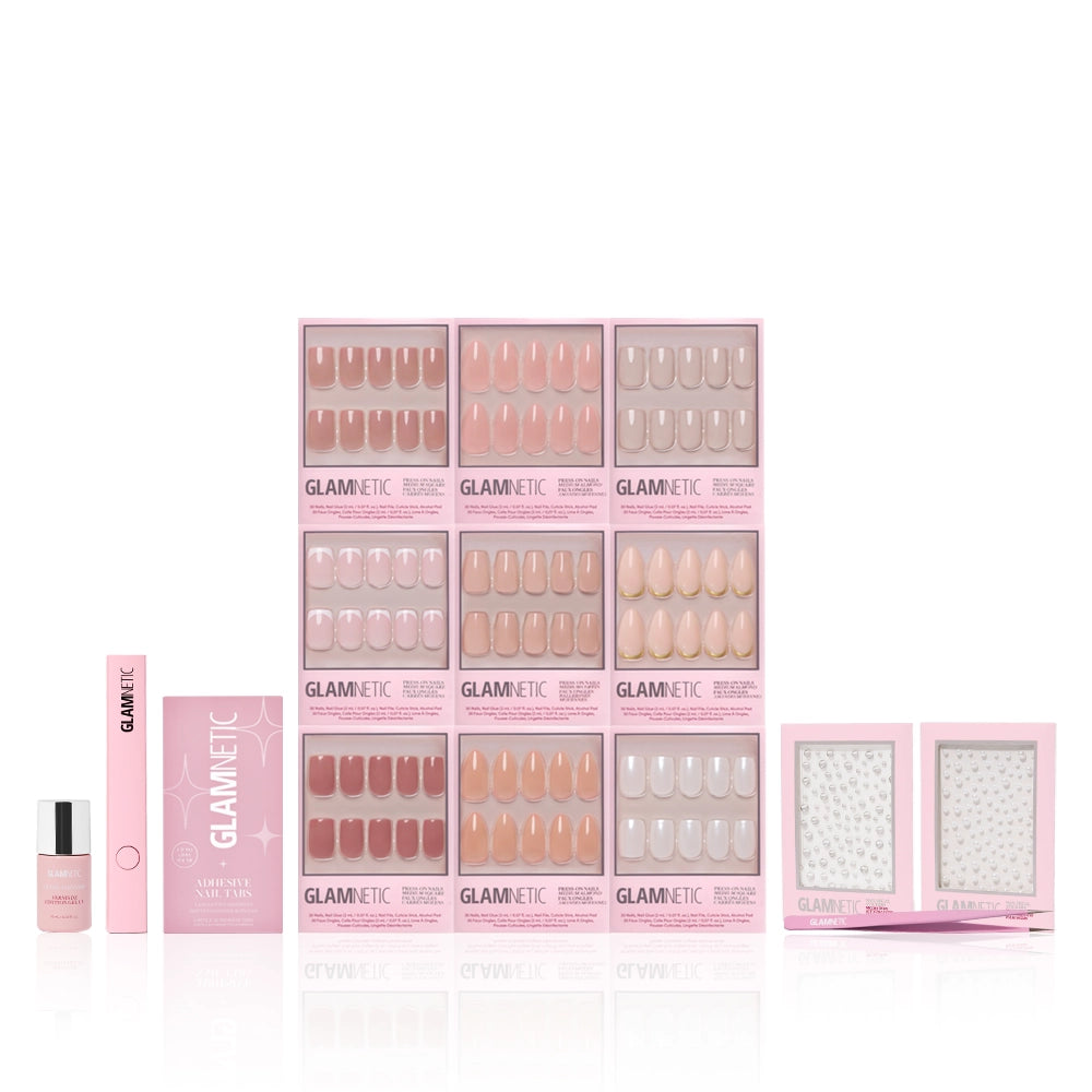 The glamnetic Timeless Studio Kit, featuring nude and pink nail sets, nail glue, applicator tool, and Nail Decal Stickers, is arranged neatly on a white background. - Product image