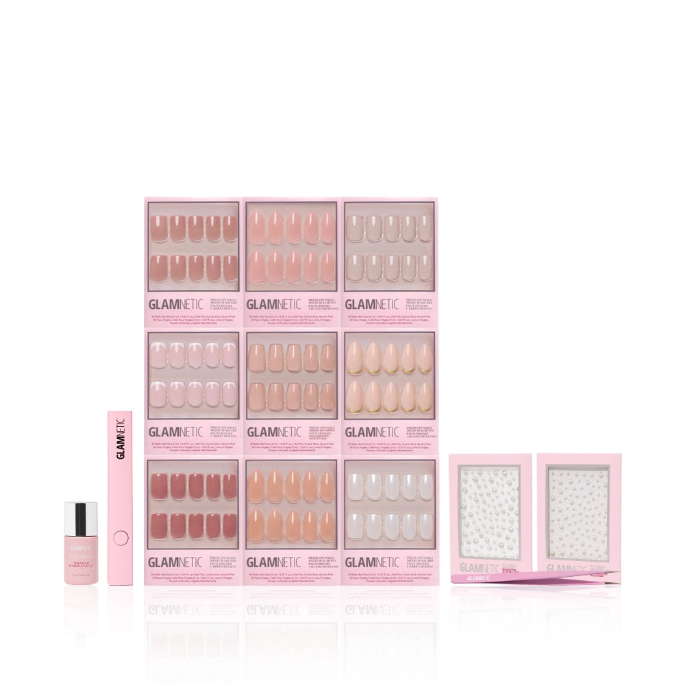 The glamnetic Timeless Studio Kit features pink-themed nail sets and accessories—blister packs with multiple nail designs, Nail Decal Stickers, a nail file, glue, and a nail polish—arranged neatly against a white background. - Product image