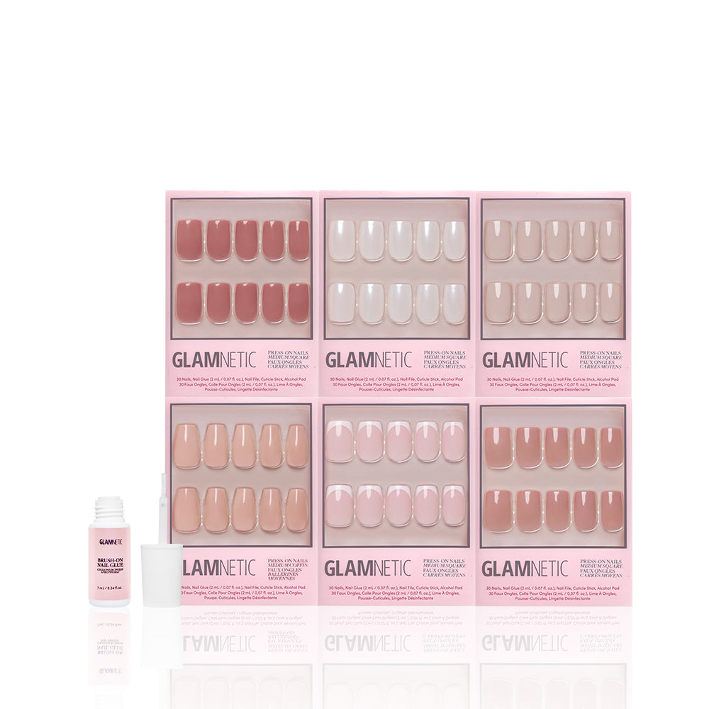 Six boxes of glamnetic’s The Sculpted Set press-on nails in assorted nude and pink glossy shades are displayed in two rows, with a nail glue bottle and applicator positioned on the left against a white background. - Product image