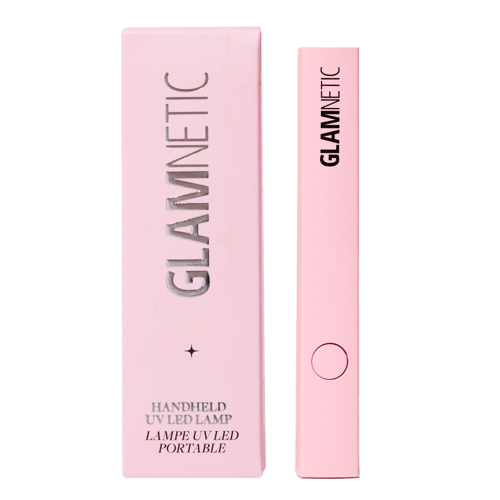 A pink glamnetic Handheld UV LED Lamp stands upright beside its matching box, ideal for curing gel nails or extending the wear of press-ons. The box shows “glamnetic” and product info in silver and black text.