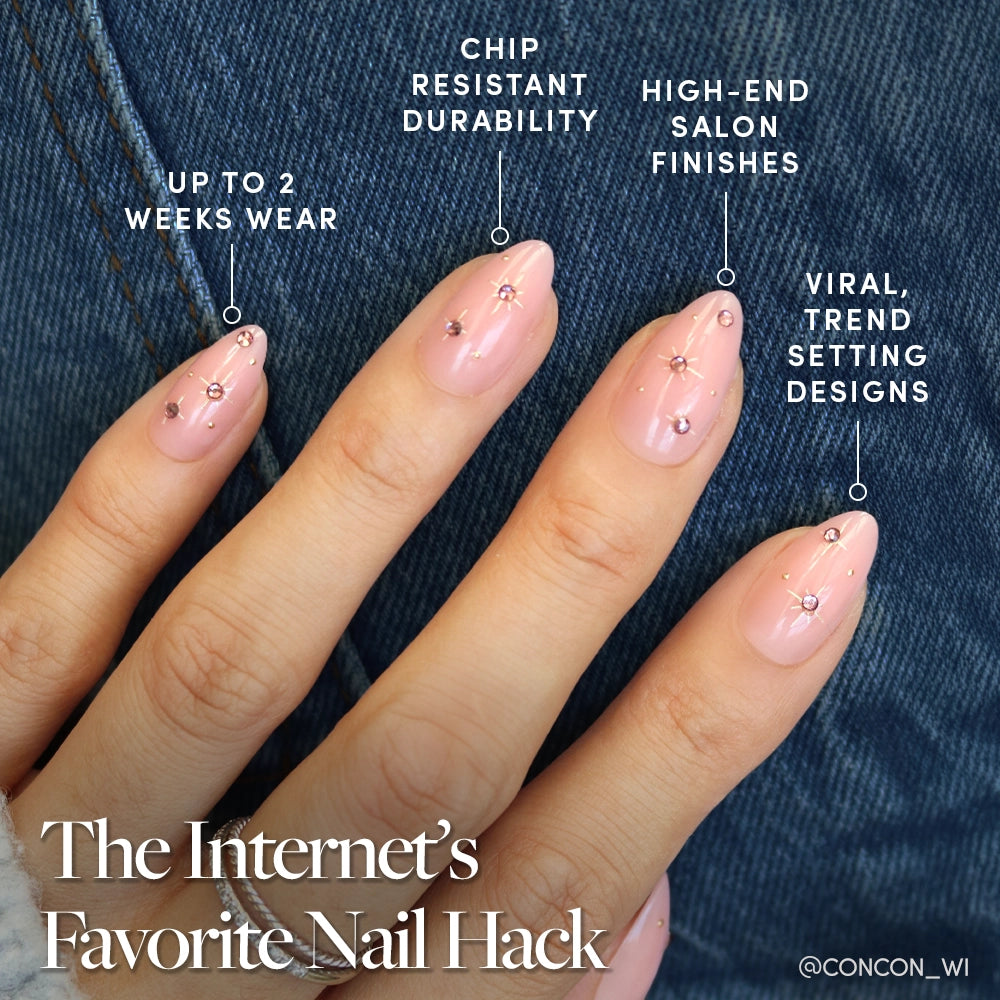 A hand with manicured short almond nails wears the glamnetic Pink Comet set—light pink polish, shiny top coat, and gold foil stars over denim. Get long wear, chip resistance, salon-quality finish, and on-trend nail art. - Product image
