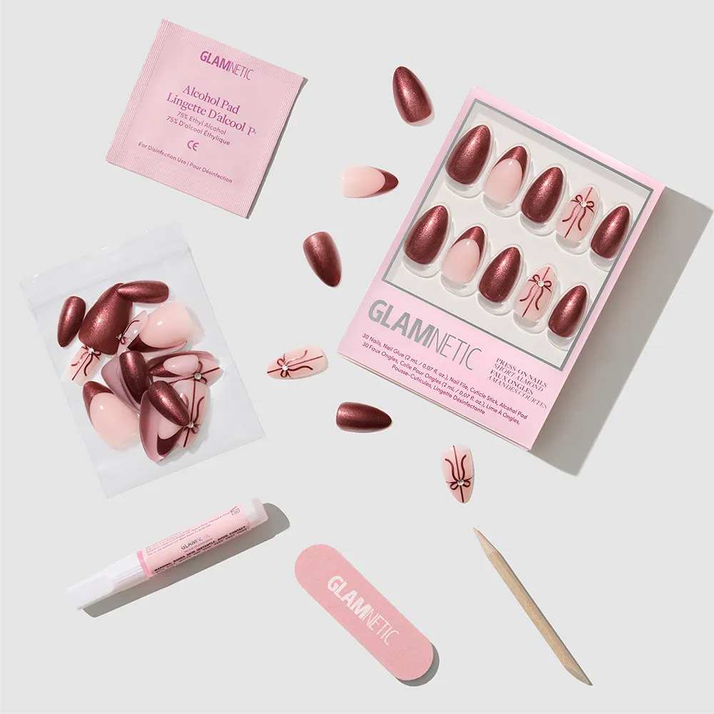 The glamnetic She's A Gift nail set features short almond nails in pink and burgundy chrome, plus nail glue, file, cuticle stick, alcohol pad, and extra nails—all arranged neatly on a white background. - Product image