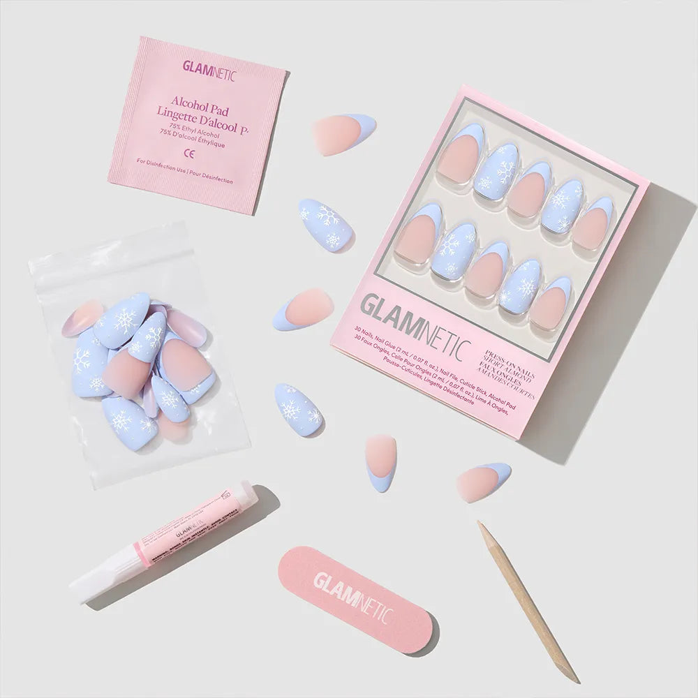 The Snow Bunny Nail Set by glamnetic includes pastel pink and blue matte almond nails with snowflake designs, plus a pink nail file, wooden cuticle stick, nail glue, alcohol pad, and extra nails for a flawless winter manicure. - Product image