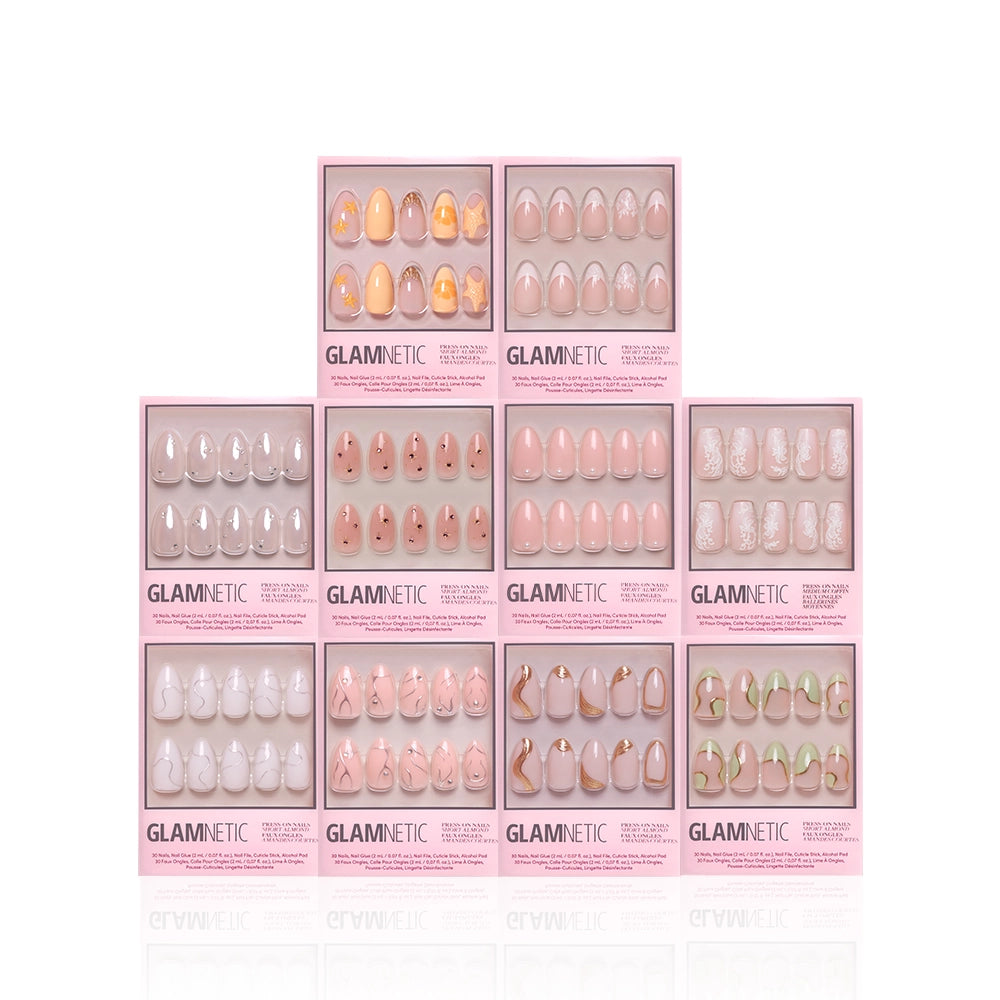 Ten boxes of glamnetic's It's Giving More Dimension press-on nails are stacked in a pyramid. Each box, with a clear window, displays unique 3D pink, nude, and pastel designs—including short almond nail sets. - Product image