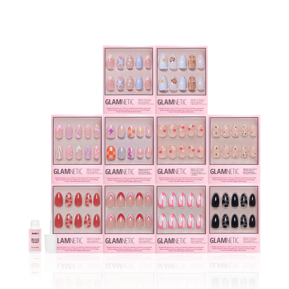 Ten boxes of glamnetic Trendy Not Spendy press-on nails with stylish designs are stacked in three rows, with a small nail glue bottle to the left, all set against a white background. - Product image