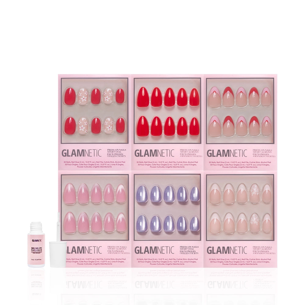 Six boxes of glamnetic press-on nails, including the Romantic Resolutions red set, are arranged in two rows with nail glue in front on a white background, highlighting easy salon-quality manicures at home. - Product image