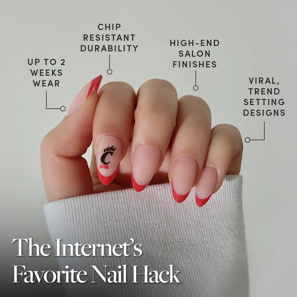 A hand with neatly manicured red French tips and unique eyelash and C designs displays the glamnetic Cincinnati Bearcats Press-On Nail Set, offering salon-quality, long-lasting wear, trendy looks, and durable finish for up to 2 weeks. - Product image
