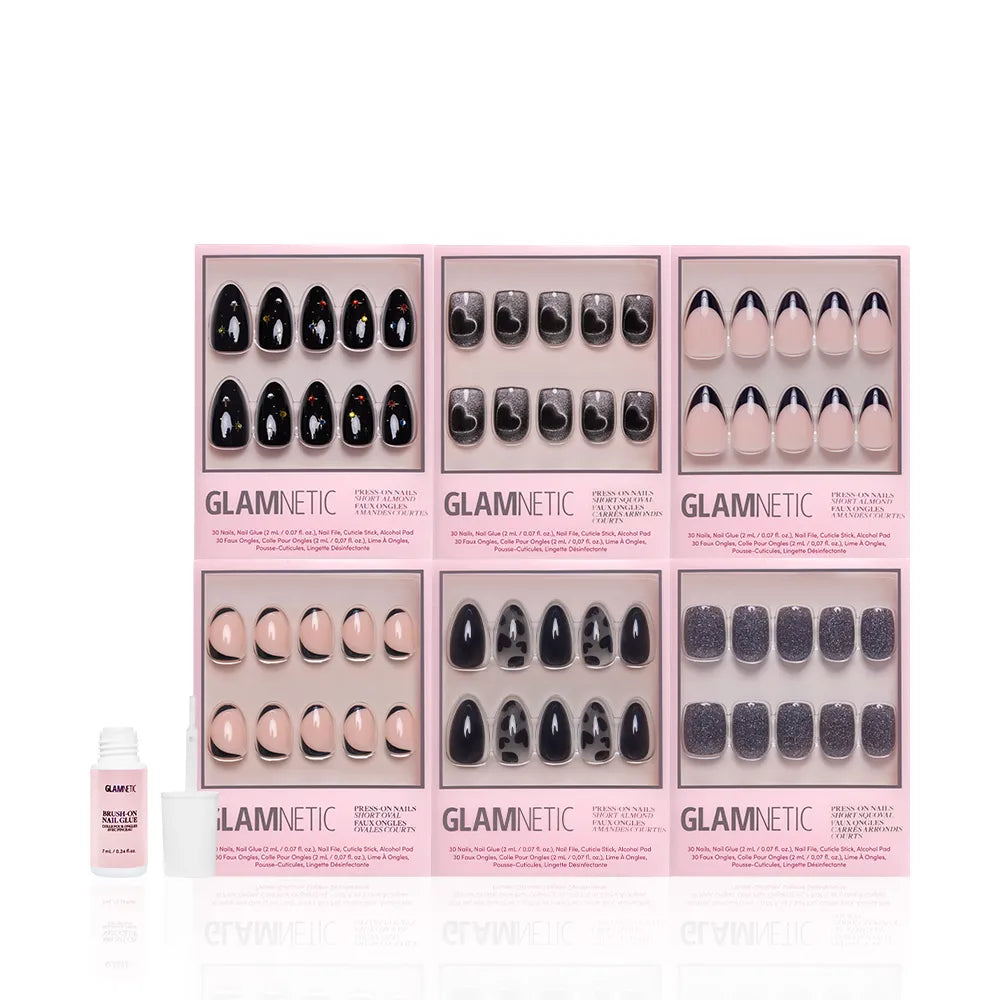 The glamnetic Countdown in the City Bundle showcases six press-on nail sets, featuring black and glitter designs in pink boxes, with nail glue included—making it the perfect set for New Year's nails. - Product image