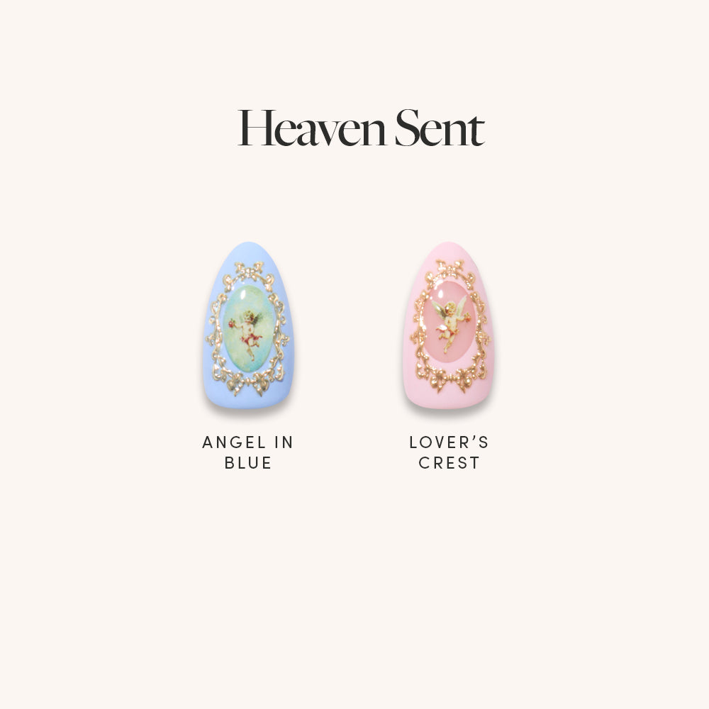 Two cherub-themed nails from glamnetic’s “Heaven Sent”: Left is “Angel in Blue,” a blue almond set with 3D gold and an angel; right is “Lover’s Crest,” a pink nail with gold trim and angel art. Text above: Heaven Sent.