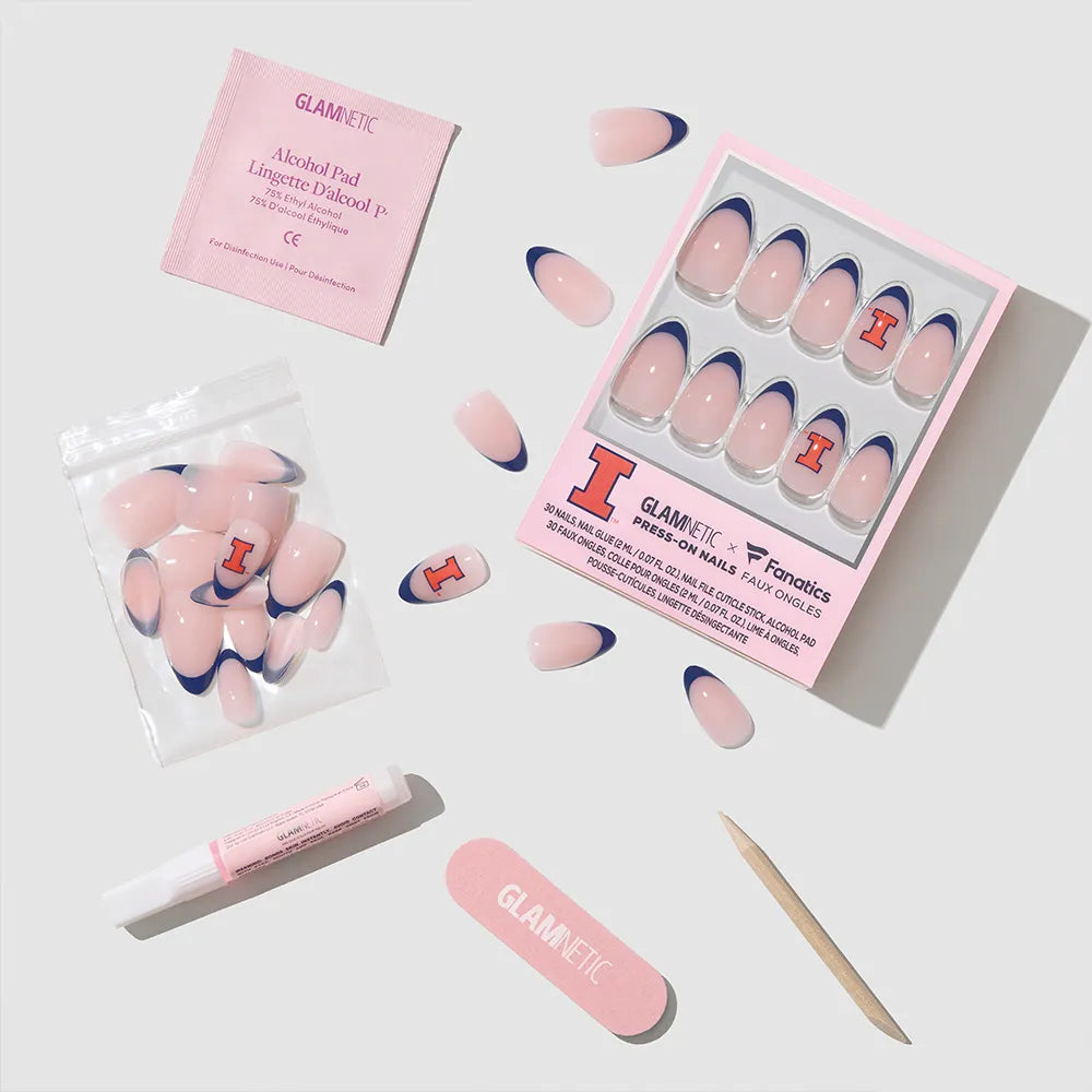 The glamnetic Illinois Fighting Illini Press-On Nail Set features team-inspired nails, an alcohol pad, nail glue, a pink file, a wooden cuticle stick, and extra nail tabs, all arranged neatly on a light gray background. - Product image