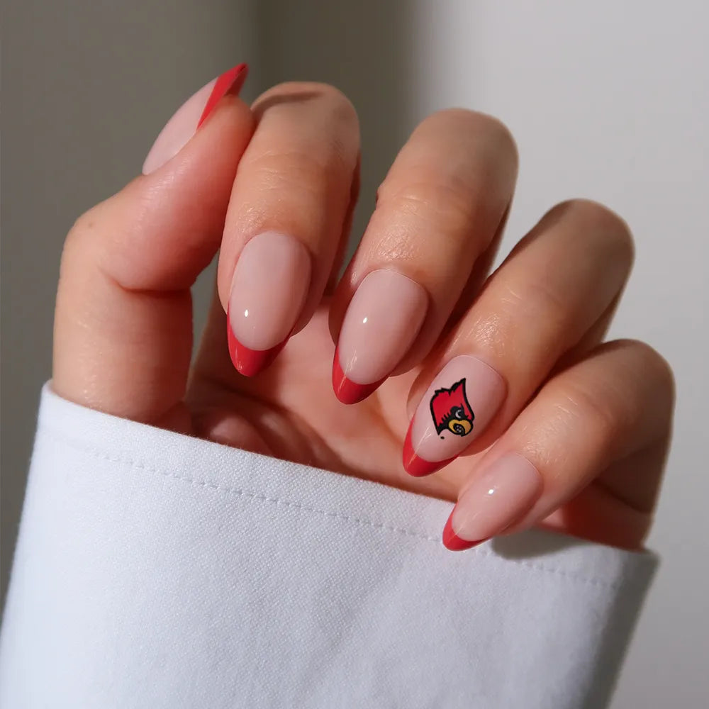 Show off your team spirit with the glamnetic University of Louisville Cardinals Press-On Nail Set—almond-shaped, nude with red French tips, and a Cardinals logo accent nail for the perfect officially licensed fan manicure. - Product image