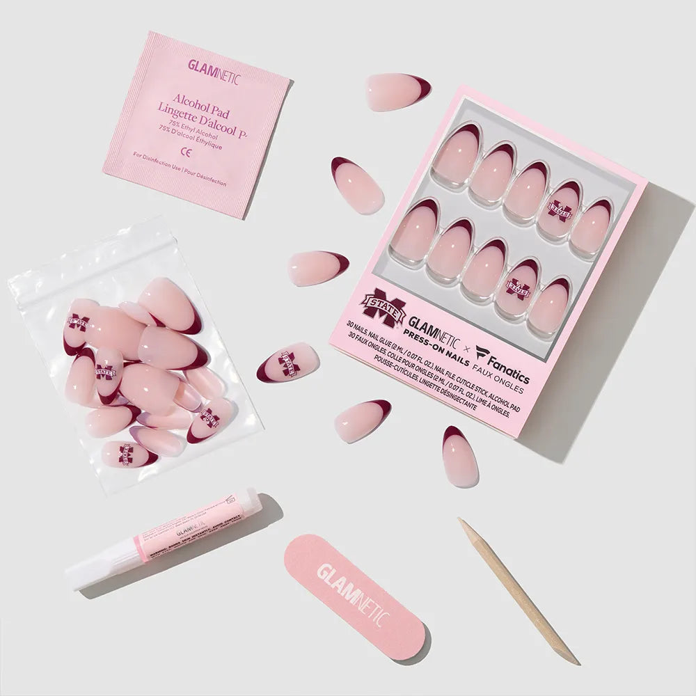 The glamnetic Mississippi State Bulldogs Press-On Nail Set features team-inspired designs and includes an alcohol pad, nail glue, nail file, and wooden cuticle stick—everything arranged neatly for easy application. - Product image
