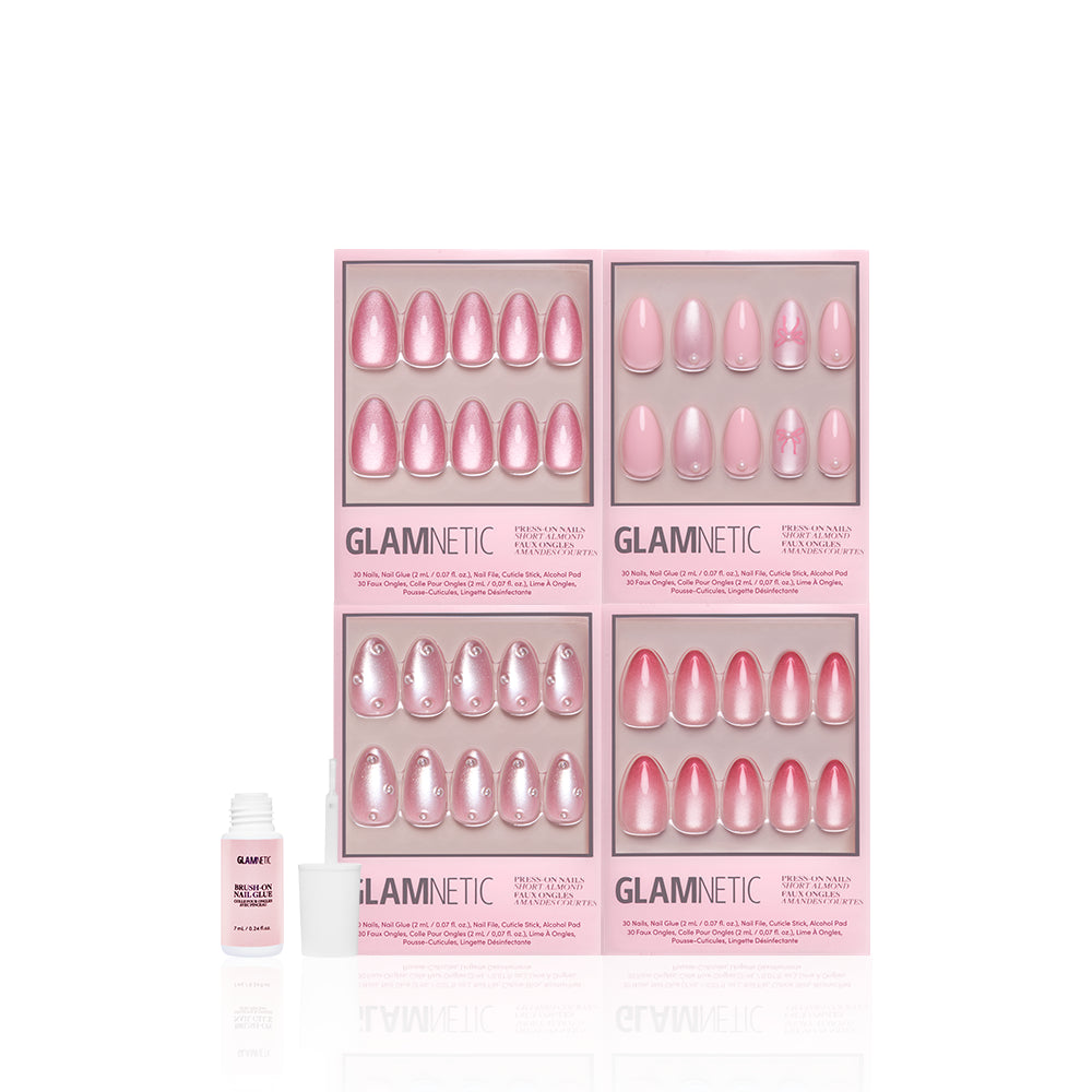 Four sets of glamnetic Velvet Valentine pink press-on nails with blush designs are displayed in rectangular boxes, alongside a small white bottle of nail glue with its cap off, all on a white background. - Product image