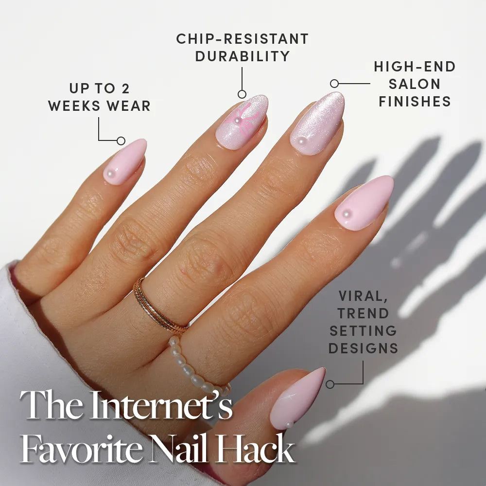 A hand with long, almond-shaped Love Knot press on nails by glamnetic features 3D pearl accents and a shimmery finish. Benefits: 2 weeks wear, chip-resistant, high-end, trend-setting design. Rings and natural sunlight complete the look. - Product image