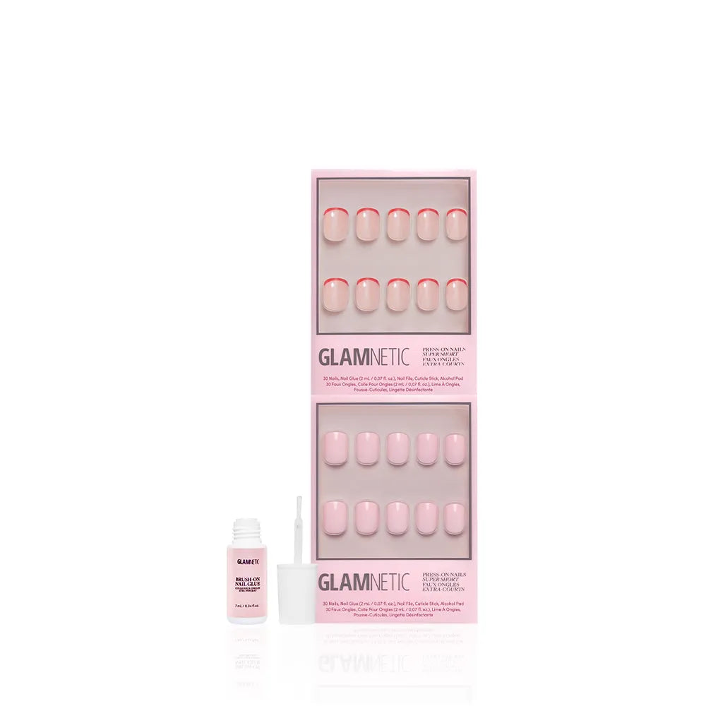 A box of glamnetic Super Short & Sweet press-on nails in light pink with subtle French tips, displayed with two trays of nails and an open nail glue bottle with a brush. - Product image