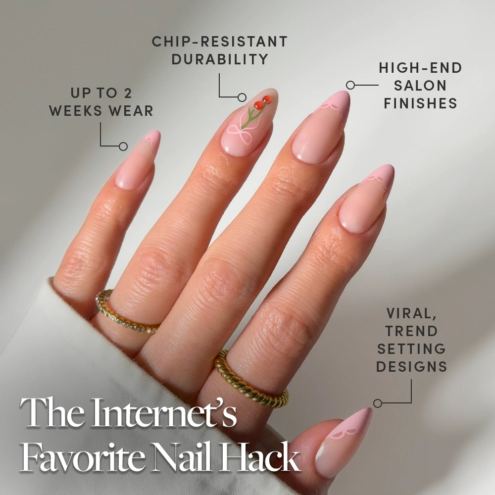 A hand with long, almond Cherry Bow press-on nails by glamnetic in pink, featuring simple designs and one floral accent. Up to 2 weeks wear, chip-resistant, high-end finish, viral trend. Caption: The Internet’s Favorite Nail Hack. - Product image