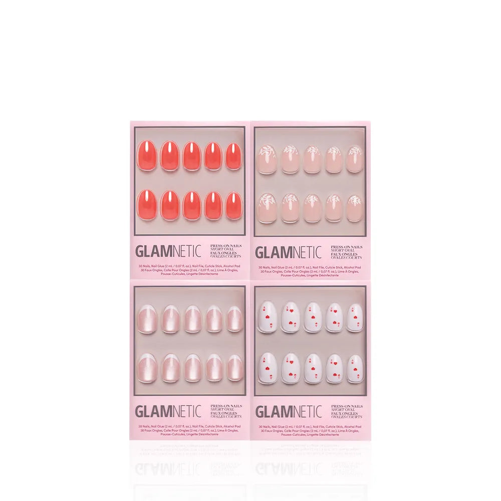 Glamnetic's The Oval Affair includes four pink-packaged press-on nail sets: solid coral, nude with white designs, pearlescent nude, and nude with small red dots for a soft-luxury classic manicure. - Product image