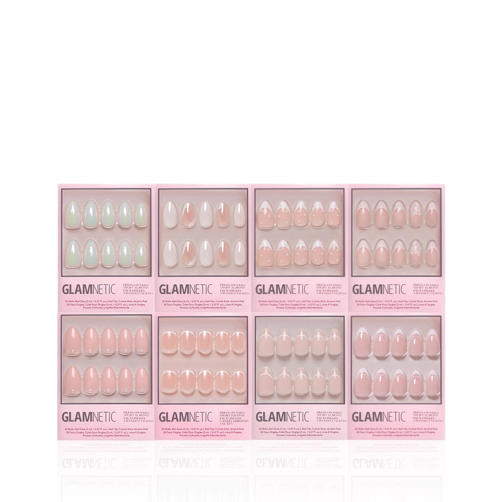 Eight boxes of glamnetic Hopeless Romantic Bundle press-on nails in pink and nude are arranged in two rows with clear windows, showing various shapes like classic French tip and short almond designs on a white background. - Product image