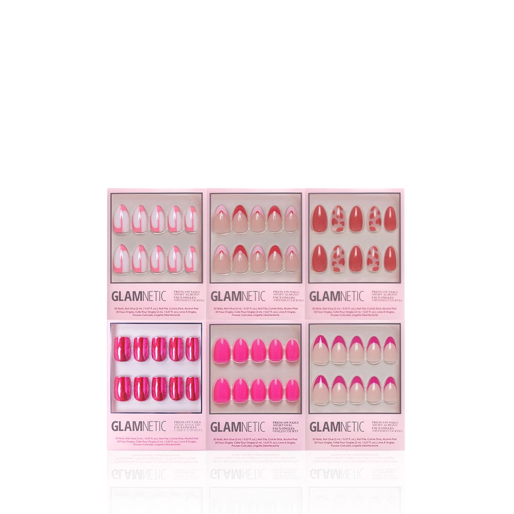 Six boxes from glamnetic’s Lover Girl Bundle are arranged in two rows, each displaying romantic pink almond press-on nails in solids, French tips, and patterns—all elegantly showcased in clear packaging. - Product image