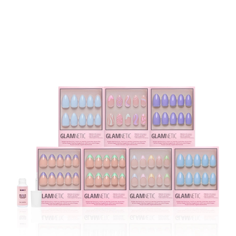 Eight boxes of glamnetic Almond Blossom pastel nail sets in various glossy designs are arranged in two rows, with a nail glue bottle on the left, all set against a white background. Ideal for trendy short almond nails. - Product image