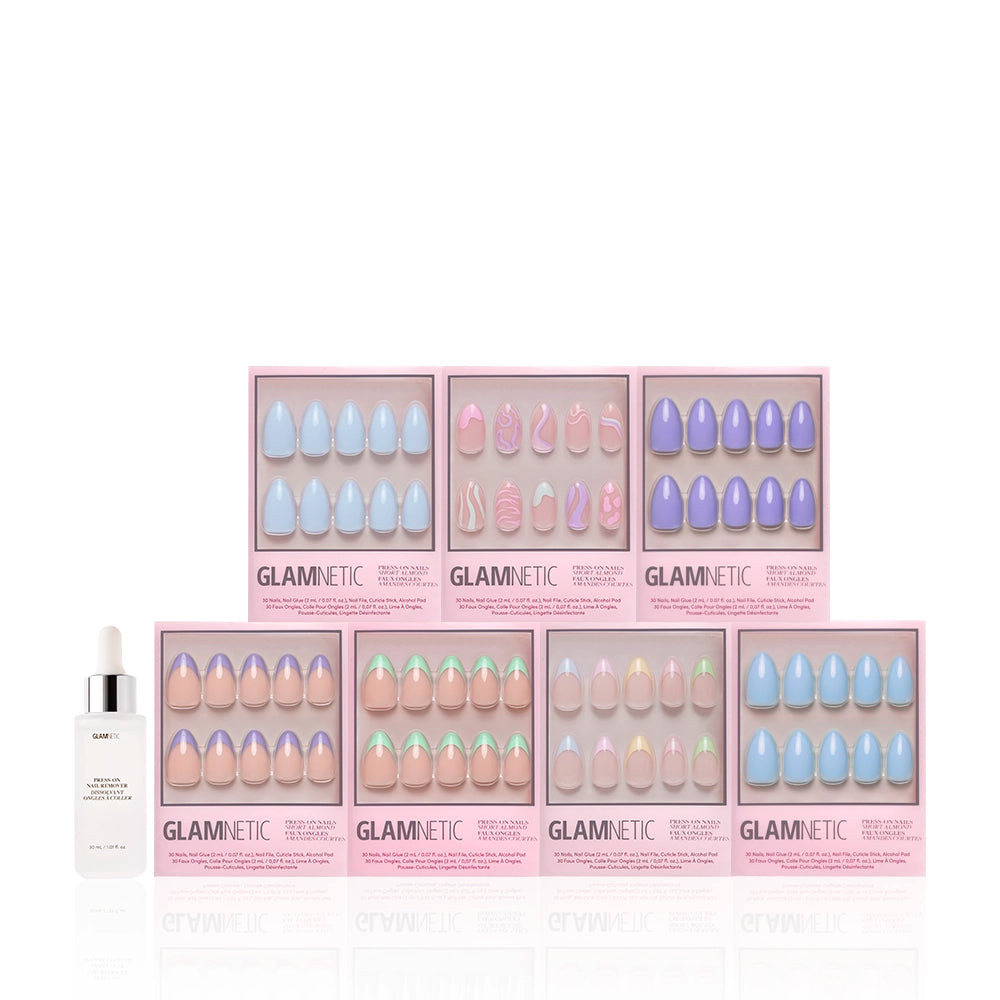 Eight boxes of glamnetic Almond Blossom pastel nail sets in assorted glossy styles are arranged in two rows, with a dropper bottle of serum or cuticle oil on the left, all set against a white background. - Product image