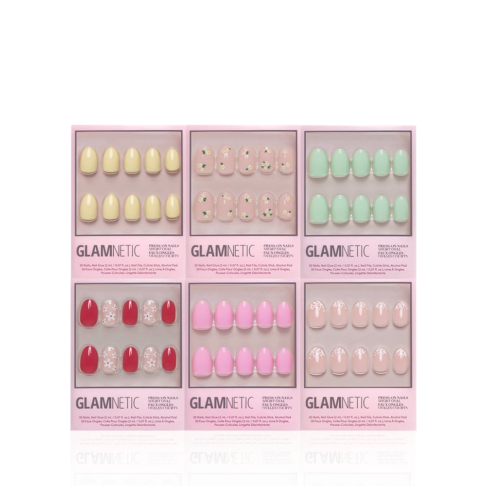 Six boxes of glamnetic Oval Petals & Polish press-on nails in assorted pastel shades—yellow, pink, red, mint green, and nude—featuring floral designs and gem accents, arranged in two rows on a white background. - Product image