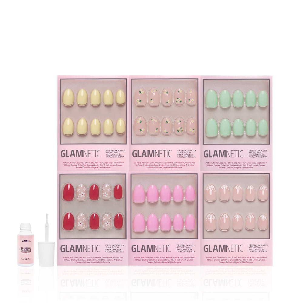 Six boxes of glamnetic Oval Petals & Polish press-on nails with floral designs and pastel shades are arranged in two rows, with a small bottle of nail glue and an applicator set in front on the left side. - Product image