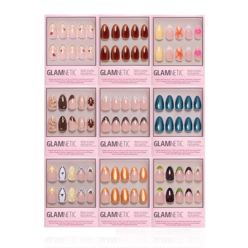 Nine sets of glamnetic Almond Amore press-on nails in pink boxes, each with unique styles—French tips, florals, geometric patterns, solid shades, and fruit art—are arranged in a 3x3 grid. - Product image